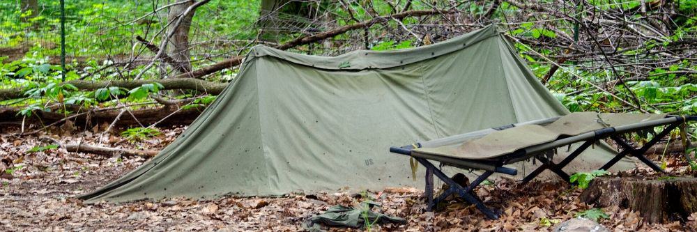 camping-cot-outside-tent-in-woods