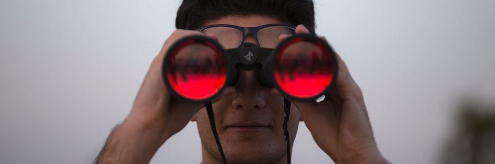 man-holding-red-binoculars