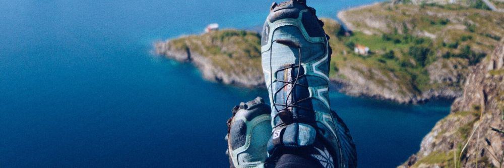 crossed hiking shoes on top of a mountain