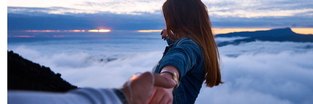 couple holding hands on mountain