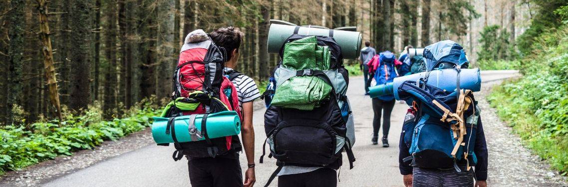 three people hiking with packs